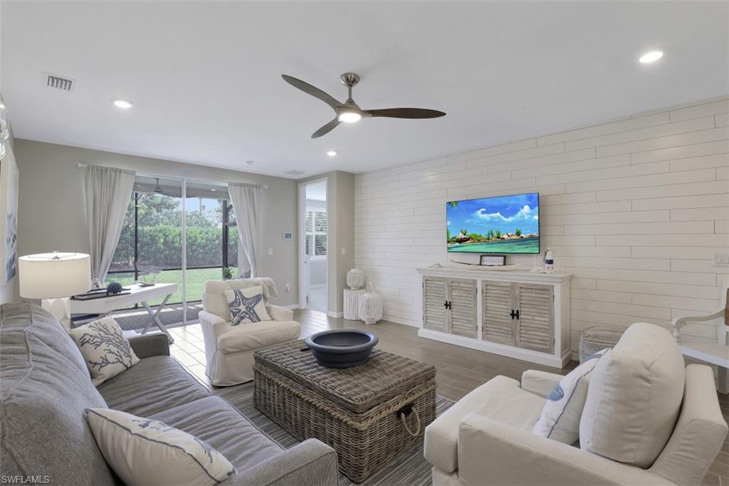 14663 Edgewater Circle Naples, FL 34114 - Photo 7 of 35 a living room with furniture and a flat screen tv