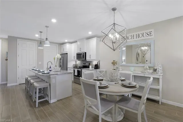 a view of a dining room and livingroom with furniture wooden floor a chandelier