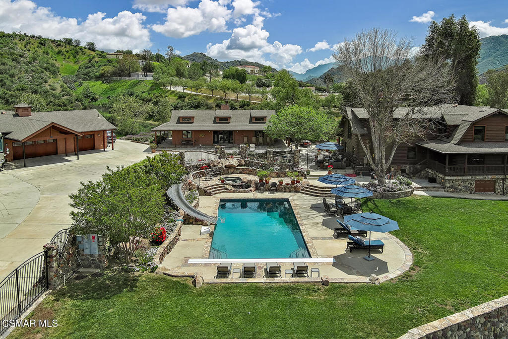 3030 Triunfo Canyon Road Agoura Hills, CA 91301 - Photo 2 of 50 a view of a swimming pool with lawn chairs and a fire pit