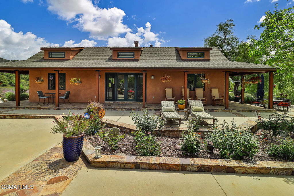 3030 Triunfo Canyon Road Agoura Hills, CA 91301 - Photo 36 of 50 a front view of a house with lots of green space and seating