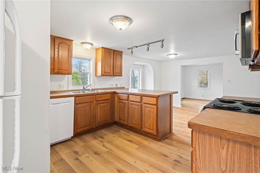 3426 Marsh Road Stow, OH 44224 - Photo 14 of 37 Kitchen with light wood-style floors, a peninsula, brown cabinets, light countertops, and white appliances