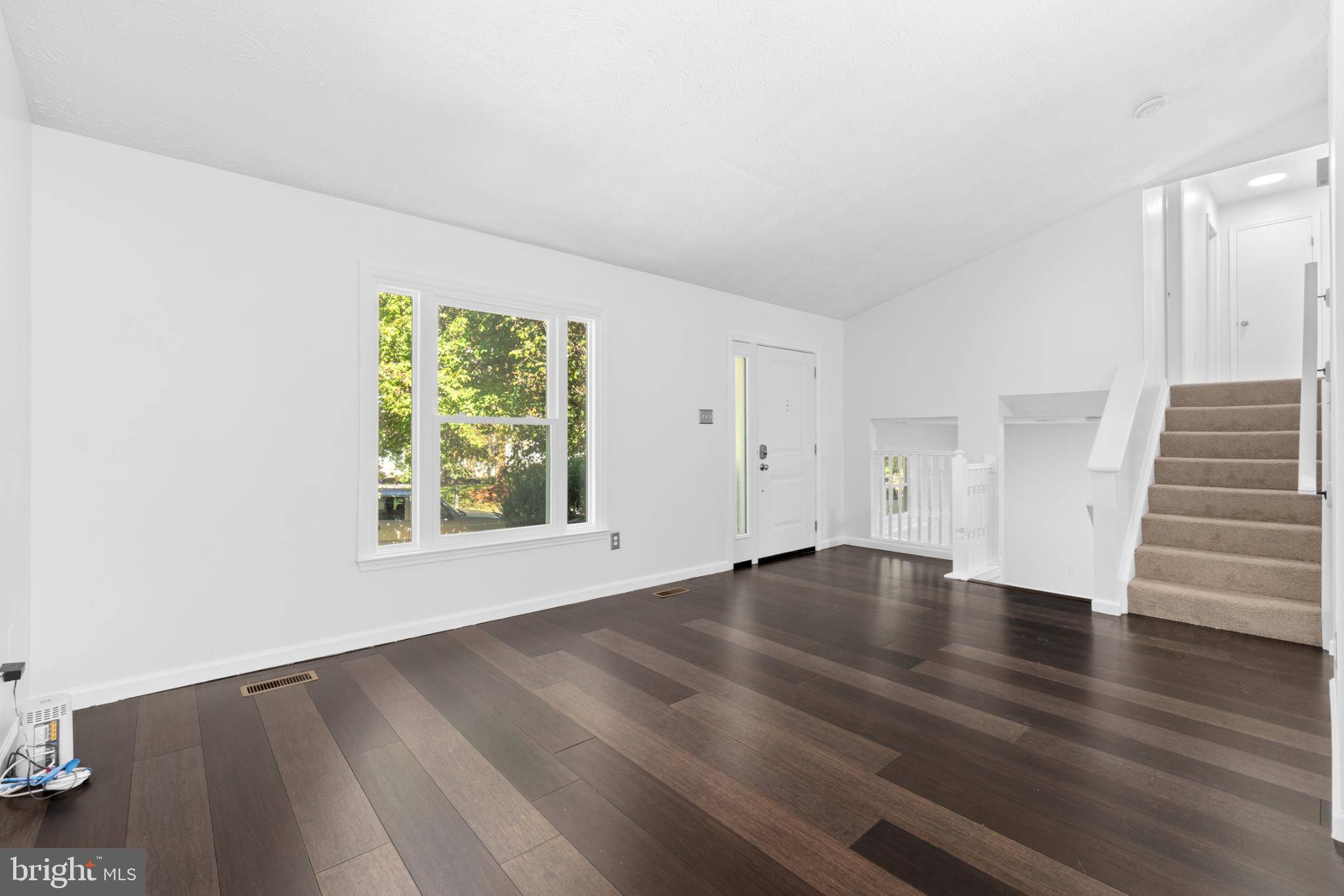9079 Manorwood Road Laurel, MD 20723 - Photo 6 of 35 an empty room with wooden floor and windows