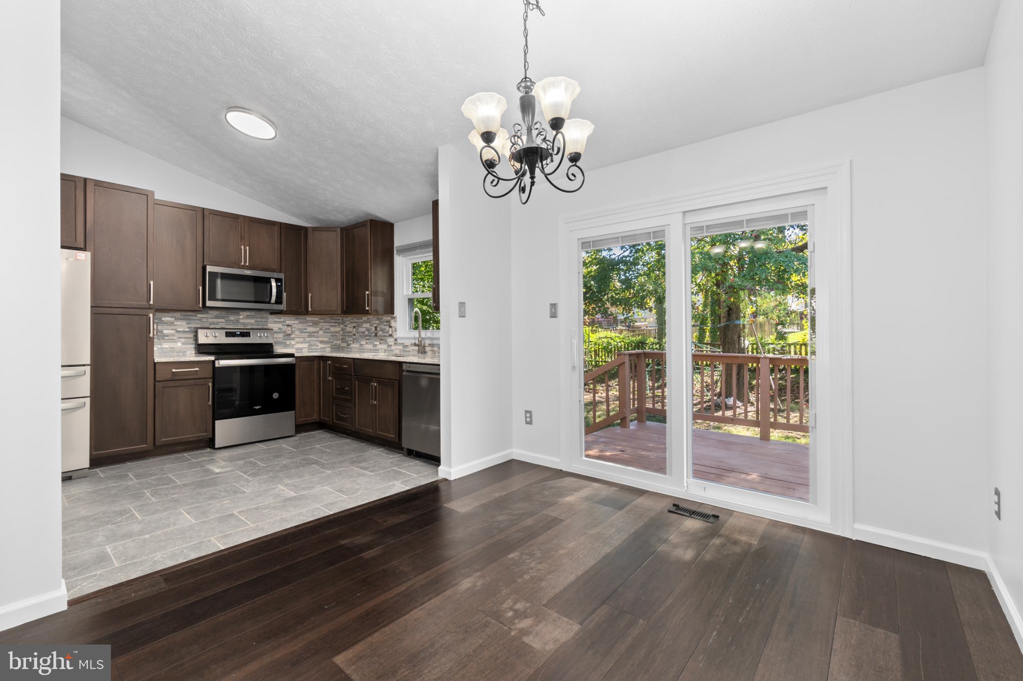 9079 Manorwood Road Laurel, MD 20723 - Photo 7 of 35 a kitchen with stainless steel appliances granite countertop a refrigerator a stove top oven a sink and dishwasher