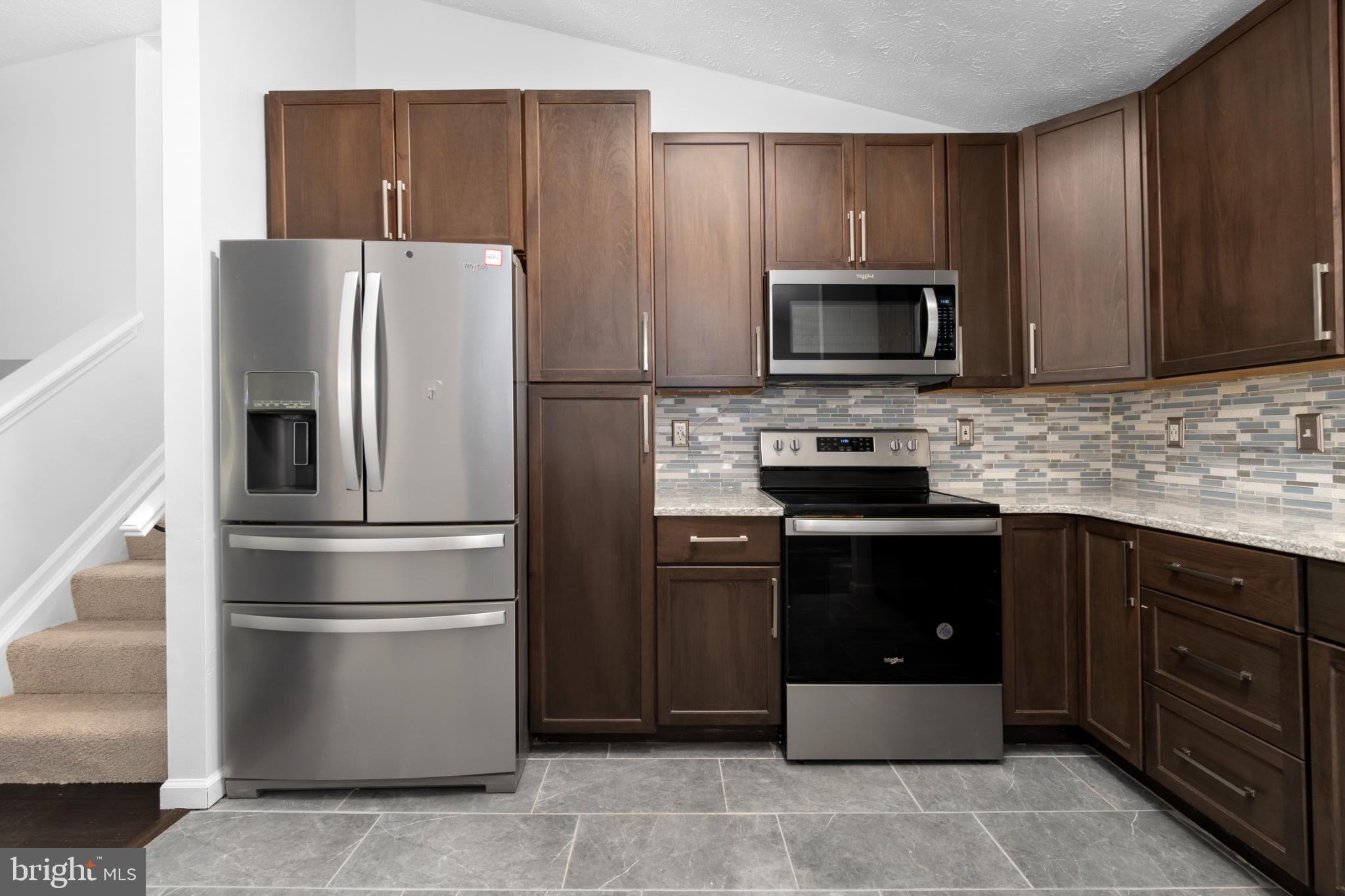 9079 Manorwood Road Laurel, MD 20723 - Photo 8 of 35 a kitchen with a refrigerator stove and microwave