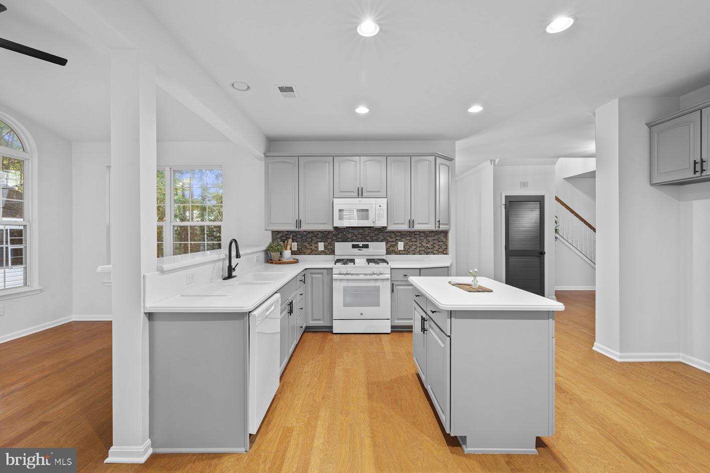 1111 Ruddy Duck Court Denton, MD 21629 - Photo 14 of 48 a kitchen with a sink a counter top space stainless steel appliances and cabinets