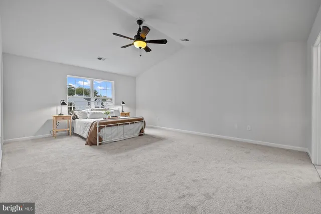 a bedroom with a bed and a chandelier fan