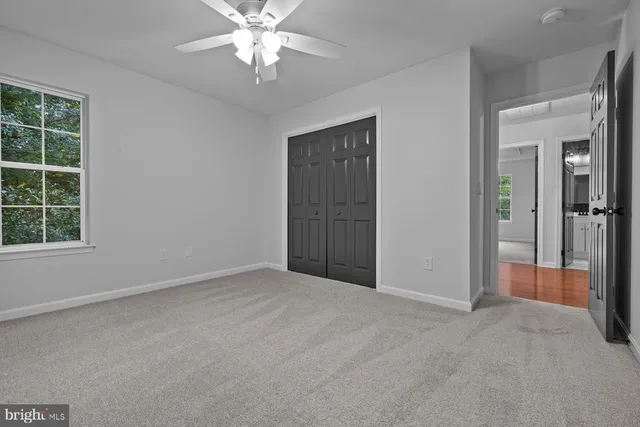 an empty room with windows and closet