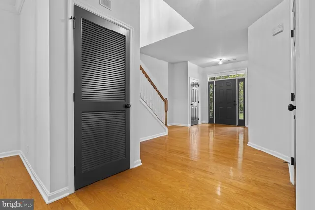a view of an empty room with wooden floor and a cabinet