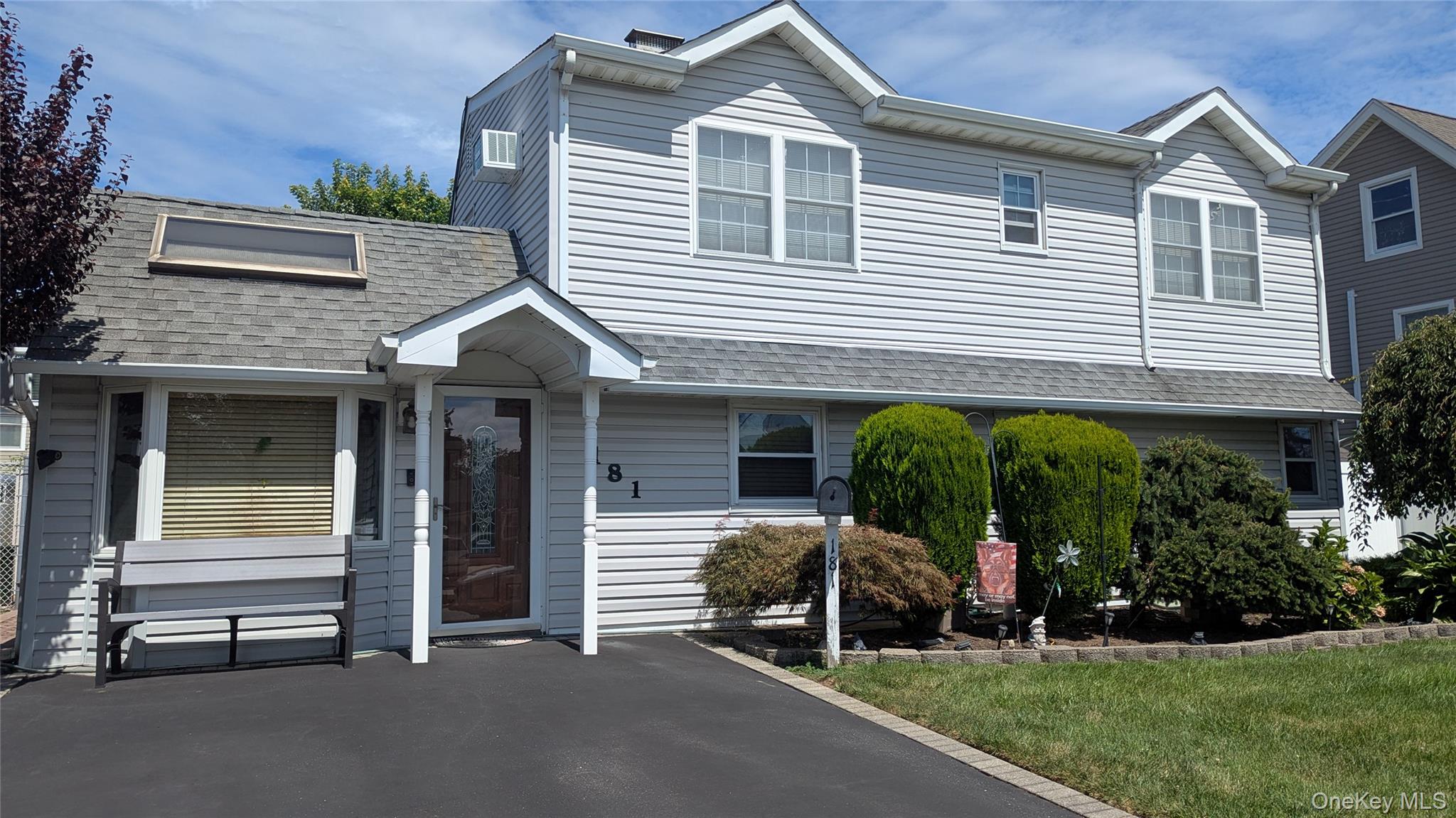 View of front of house with a shingled roof and a front yard