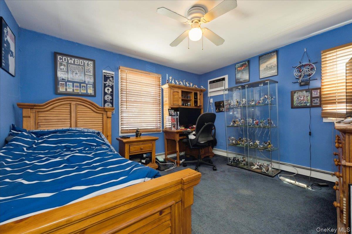 181 Springtime Lane North Levittown, NY 11756 - Photo 14 of 22 Bedroom with carpet, a baseboard heating unit, ceiling fan, and multiple windows