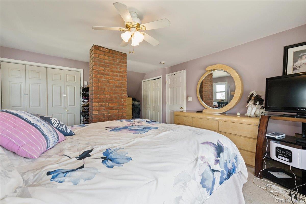 181 Springtime Lane North Levittown, NY 11756 - Photo 17 of 22 Carpeted bedroom with multiple closets and a ceiling fan