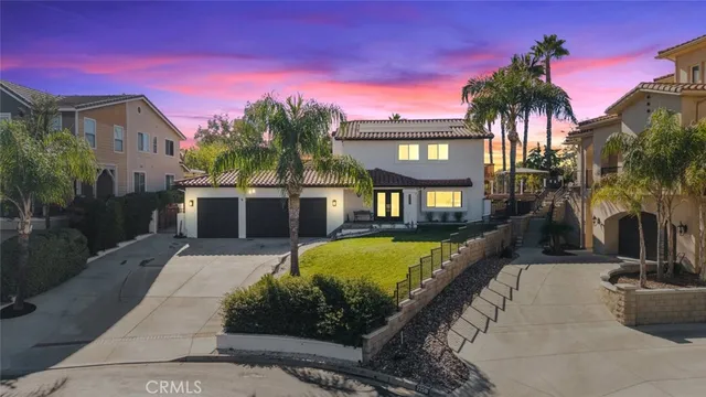 a front view of a building with glass windows and a tree