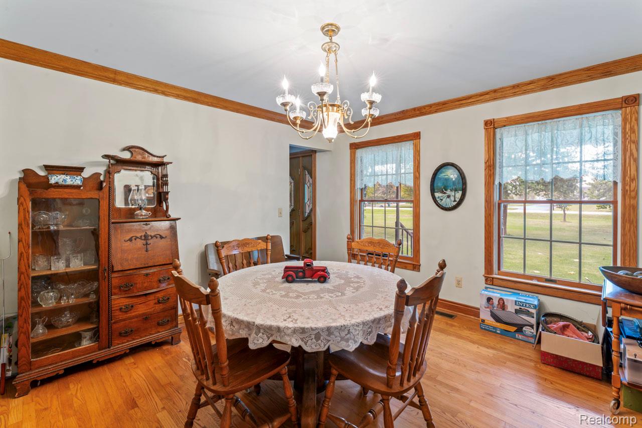 1591 Baldwin Road Lapeer, MI 48446 - Photo 11 of 46 Dining room with crown molding, light wood finished floors, and a chandelier