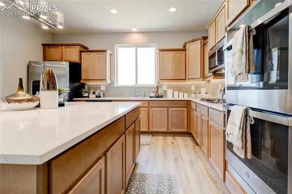 a kitchen with a sink stove cabinets and wooden floor