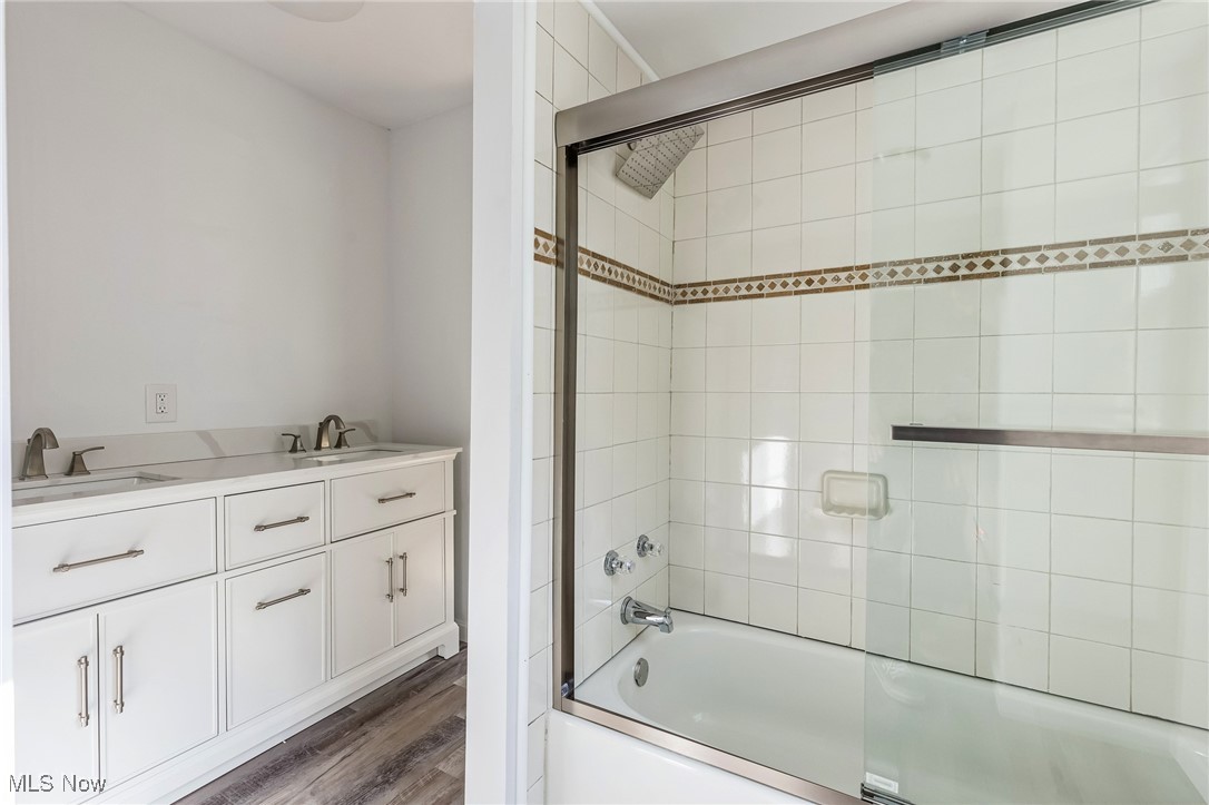 106 Berkley Road Elyria, OH 44035 - Photo 12 of 16 Bathroom featuring vanity, combined bath / shower with glass door, and hardwood / wood-style flooring