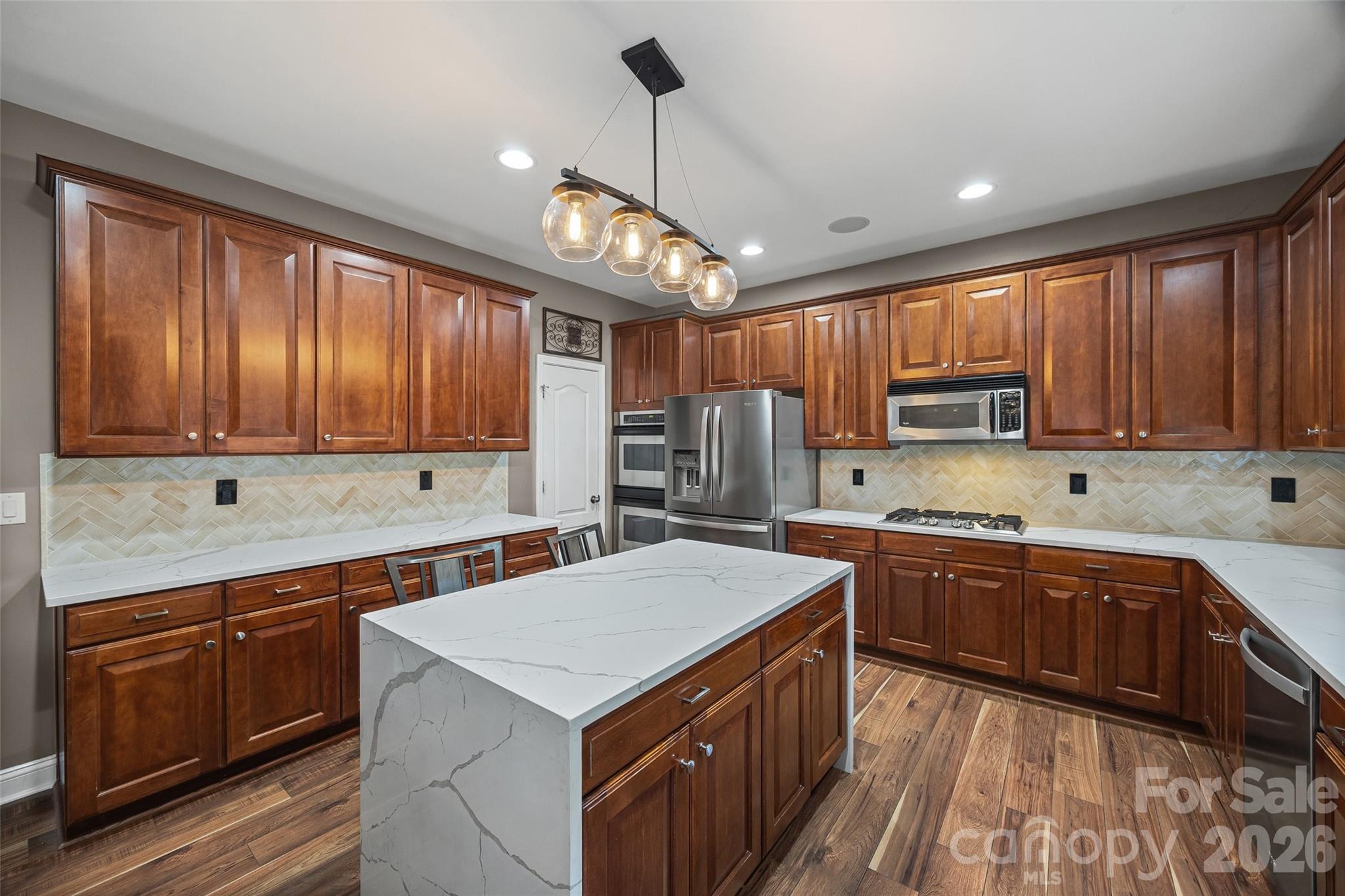 240 Loch Stone Street Fort Mill, SC 29715 - Photo 19 of 45 a kitchen with stainless steel appliances granite countertop wooden cabinets a sink dishwasher a stove and a refrigerator