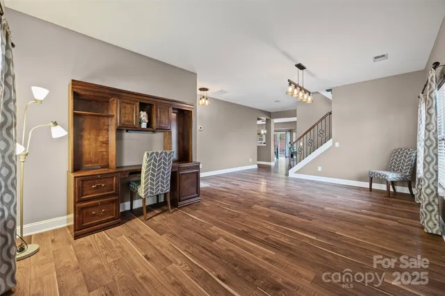 a view of a livingroom with wooden floor and furniture