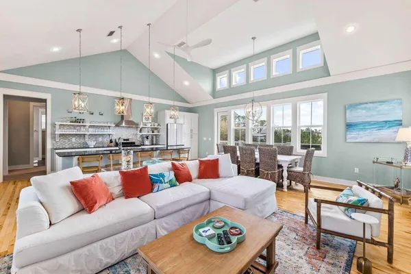 a living room with furniture kitchen view and a large window