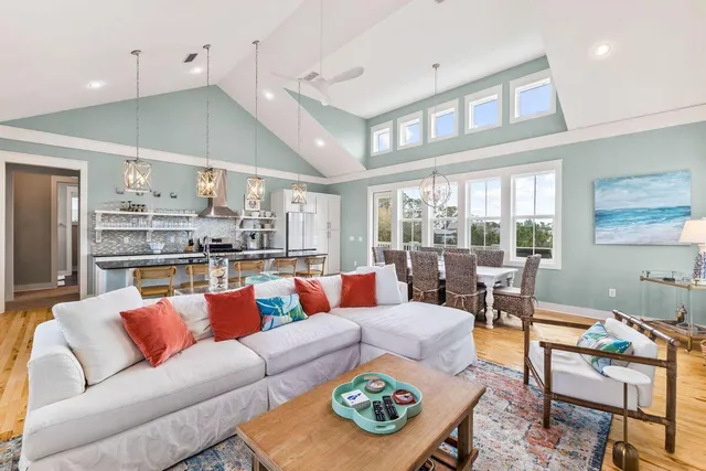 a living room with furniture kitchen view and a large window