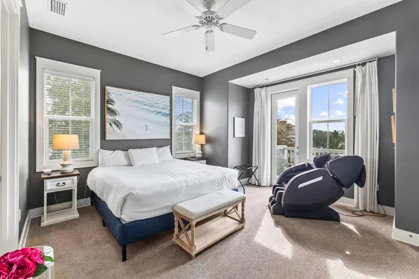 a bedroom with a bed a chandelier and large window