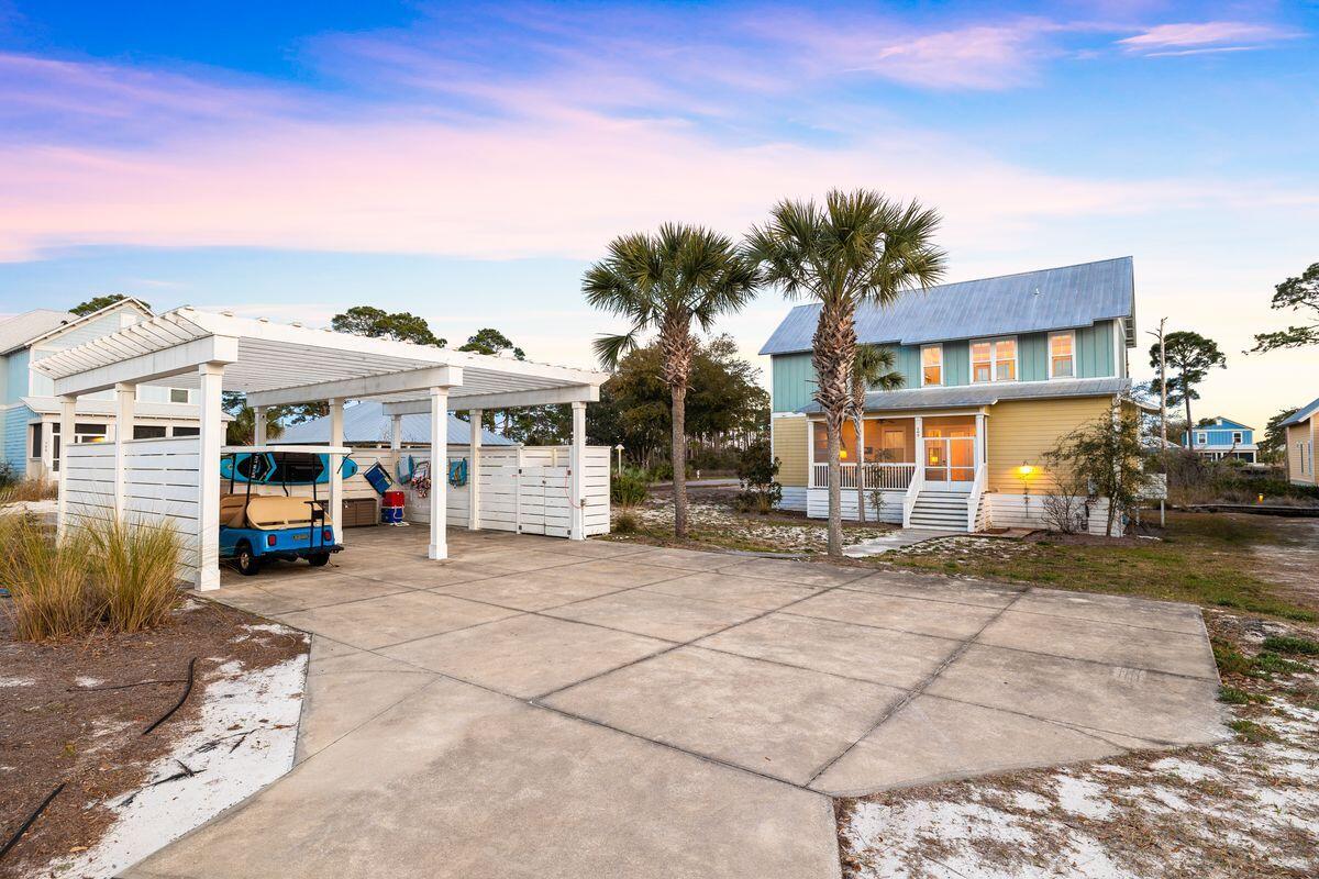 102 Goldfish Court Port St. Joe, FL 32456 - Photo 9 of 31 a view of a white house with large windows next to a road