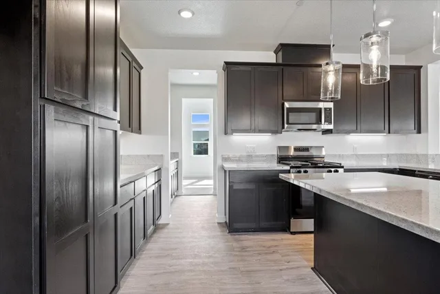 a kitchen with kitchen island granite countertop wooden cabinets and refrigerator