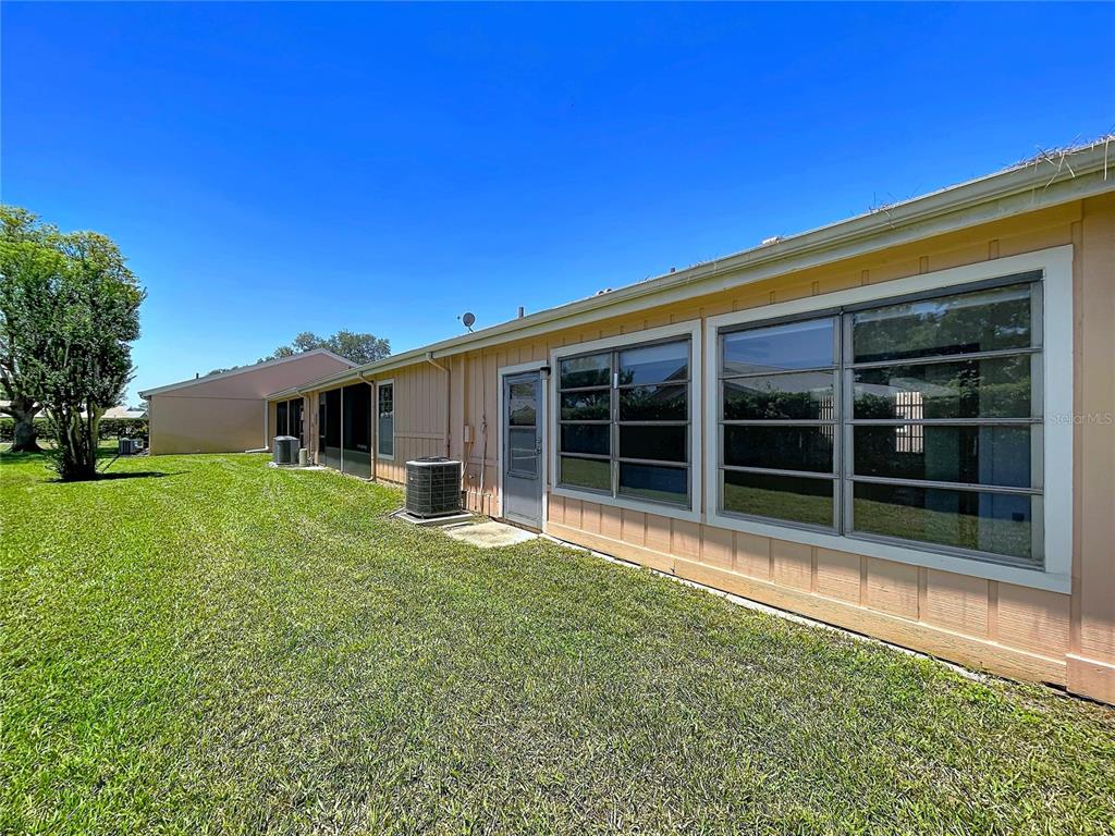 9319 Trowbridge Court New Port Richey, FL 34655 - Photo 59 of 78 a view of a house with a large window and a yard