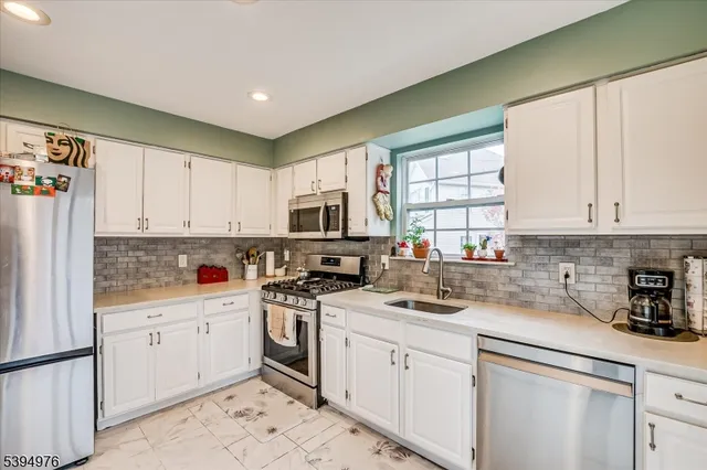 a kitchen with white cabinets sink and white appliances