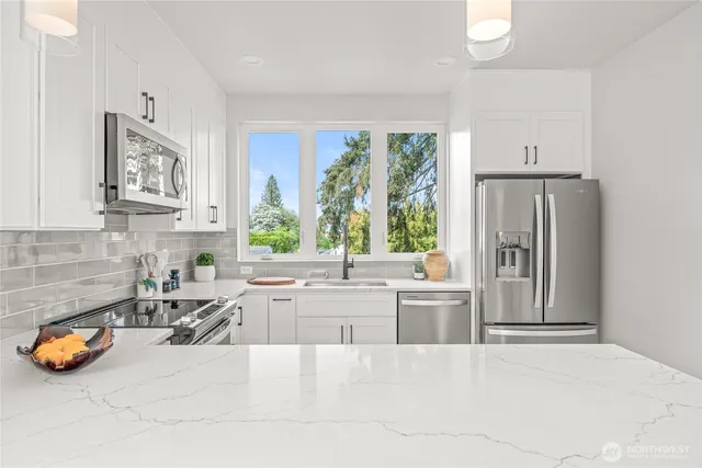 a kitchen with sink a window and chairs
