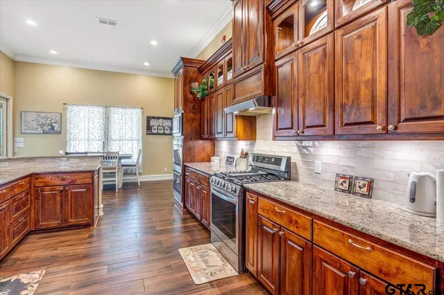 a kitchen with stainless steel appliances granite countertop a stove a sink and a refrigerator
