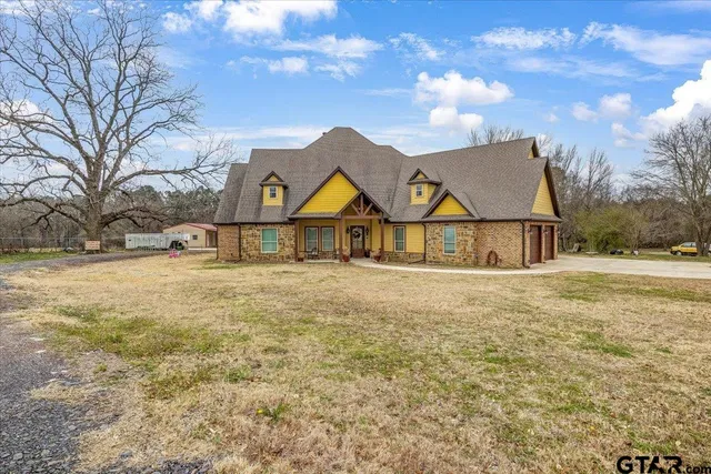 a view of a big house with big yard and large tree