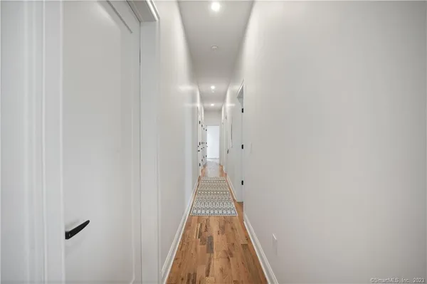 a view of a hallway with wooden floor