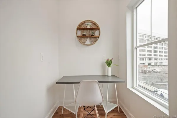 a dining room with a window and a potted plant