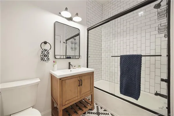 a bathroom with a toilet a sink and mirror