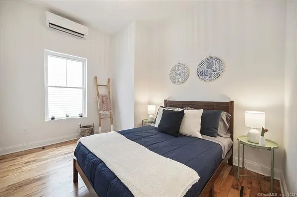 a bedroom with a bed and wooden floor