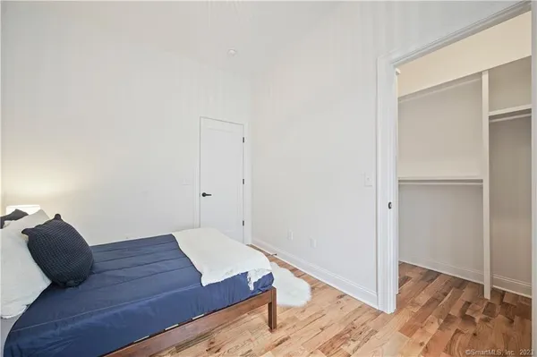 a bedroom with a bed and wooden floor