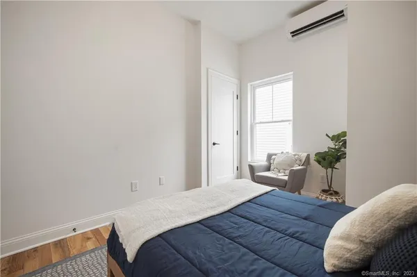 a bedroom with a bed and a potted plant