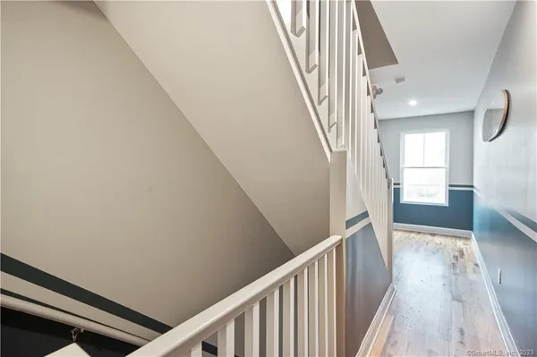 a view of a hallway with wooden floor and staircase