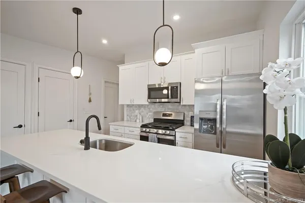 a kitchen with stainless steel appliances a refrigerator sink and microwave