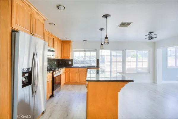 a kitchen with stainless steel appliances granite countertop sink stove and refrigerator
