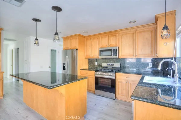 a view of a kitchen with wooden floor and windows