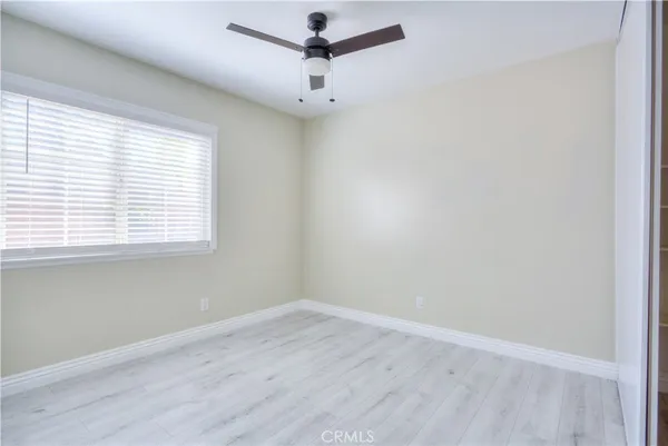 an empty room with wooden floor and a window