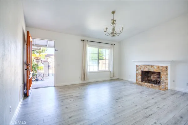 wooden floor fireplace and windows in an empty room