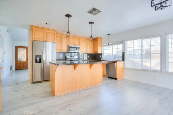 a large kitchen with stainless steel appliances granite countertop a stove and a sink
