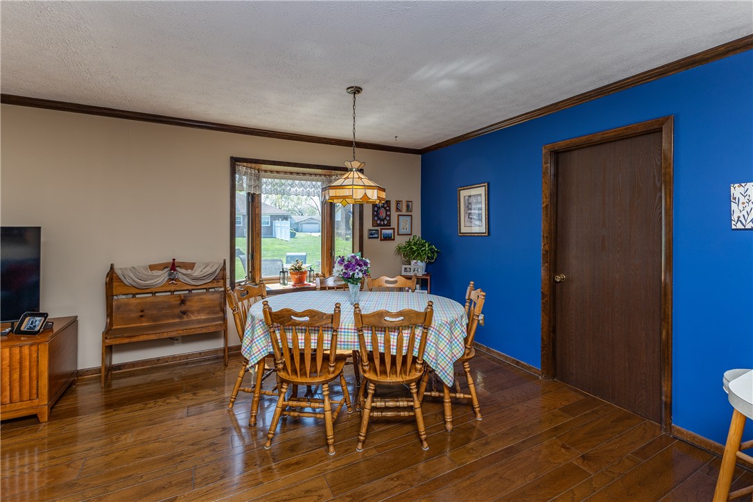 4210 Pleasanton Road Englewood, OH 45322 - Photo 11 of 34 This inviting dining area features warm hardwood flooring, a bright window, and a unique overhead light fixture.