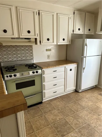 a kitchen with white cabinets and white appliances