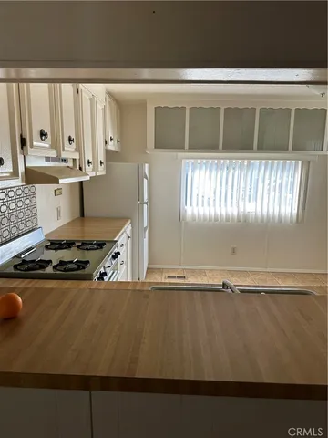 a kitchen with granite countertop a stove and white cabinets