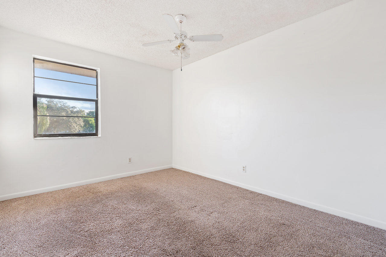 8815 Southwest 21st Street, Unit D Boca Raton, FL 33433 - Photo 14 of 27 an empty room with a fan & a window