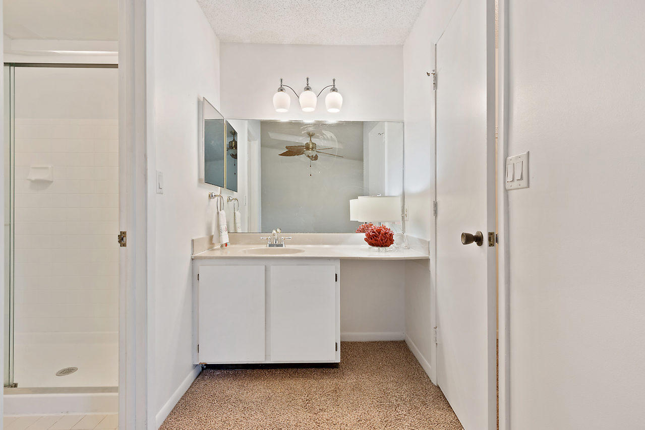 8815 Southwest 21st Street, Unit D Boca Raton, FL 33433 - Photo 18 of 27 a bathroom with a sink and mirror with shower