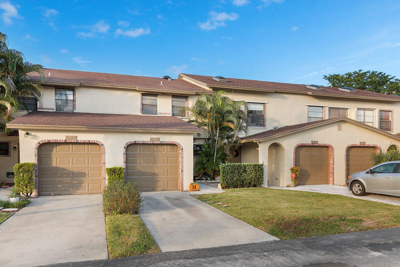 8815 Southwest 21st Street, Unit D Boca Raton, FL 33433 - Photo 2 of 27 a front view of a house with a yard and garage